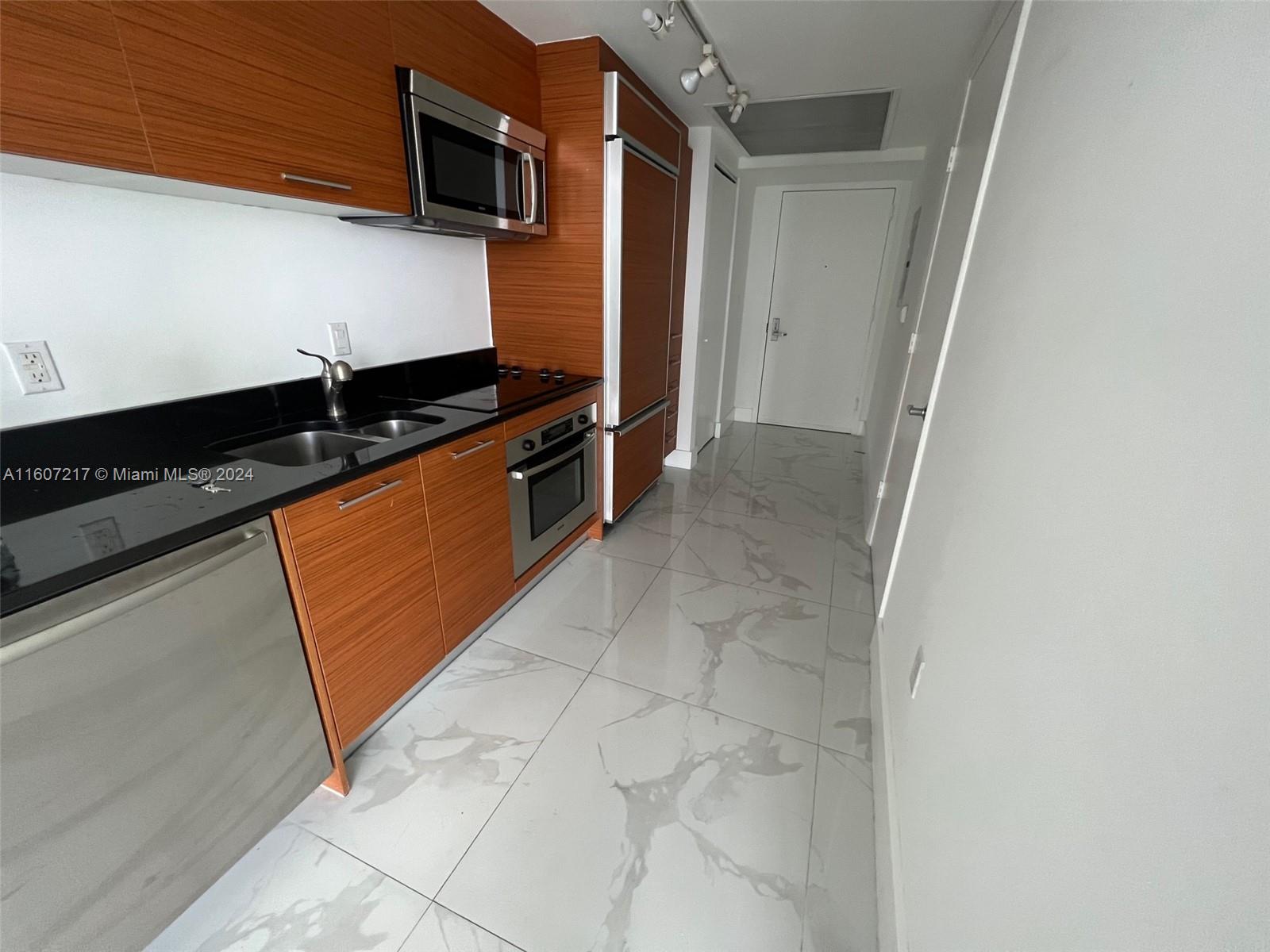 a kitchen with stainless steel appliances granite countertop a sink and a stove