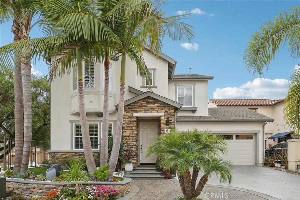 a front view of a house with a tree