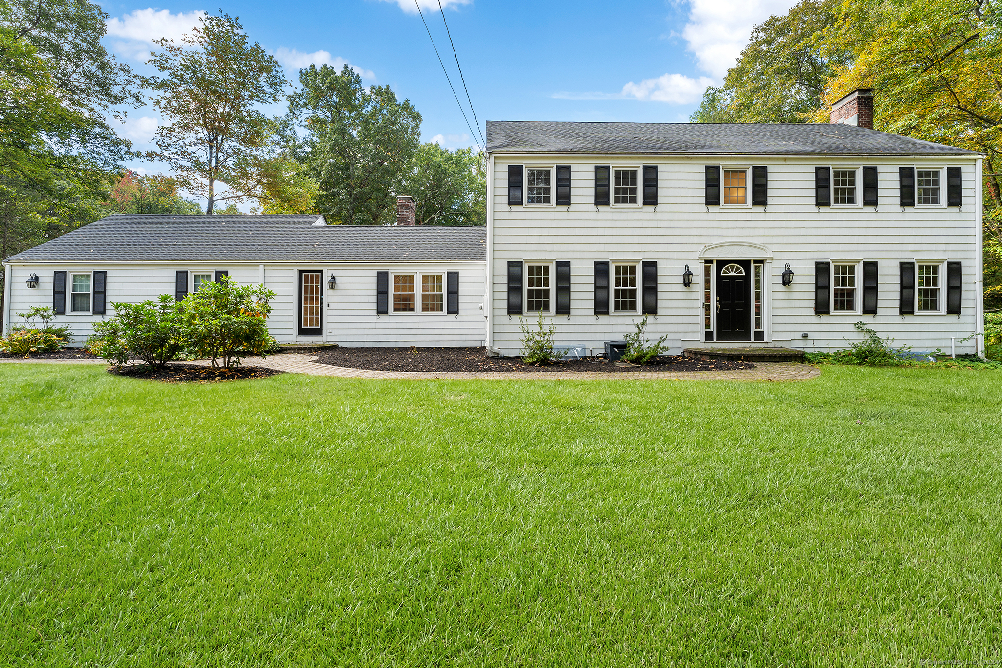 a front view of a house with a yard and trees