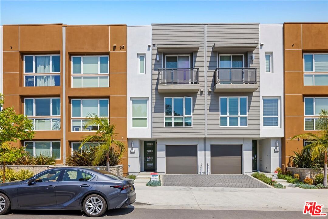 a front view of a residential apartment building with a yard