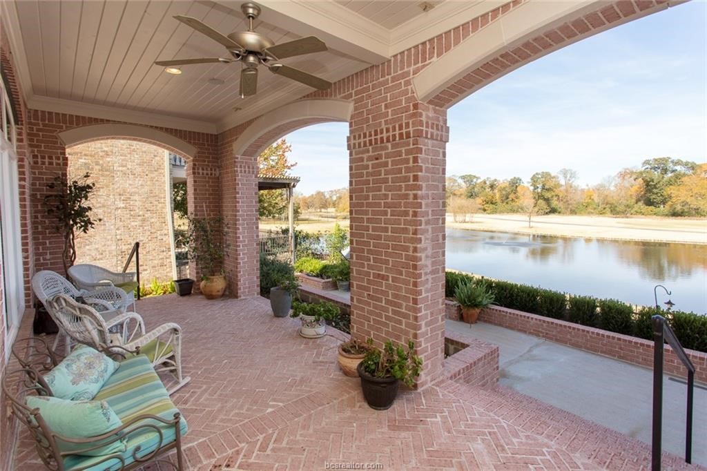 a view of a porch with furniture and a lake view