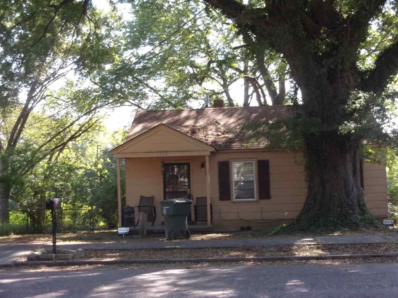 a front view of a house with a tree