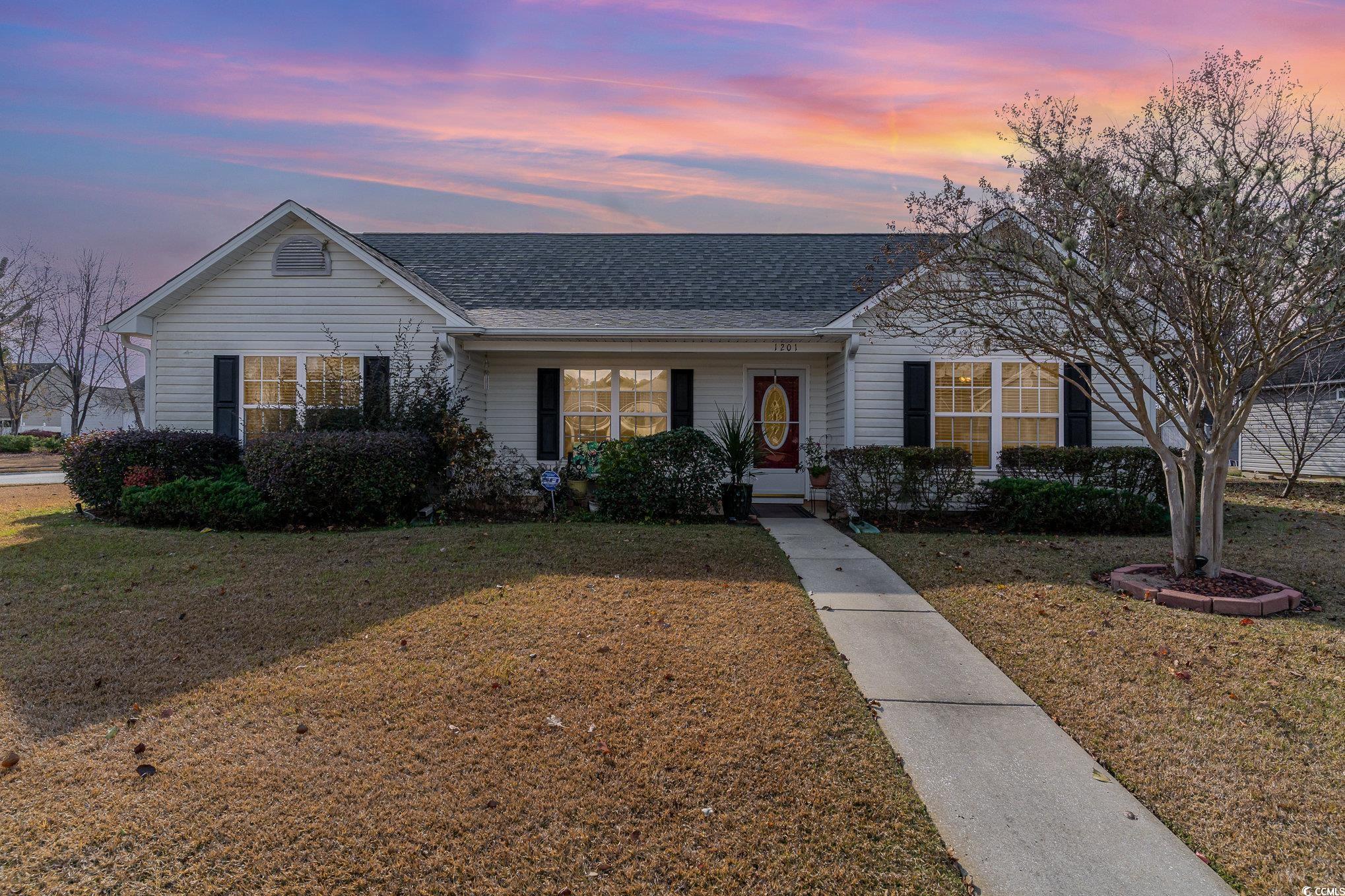 Ranch-style home featuring a lawn