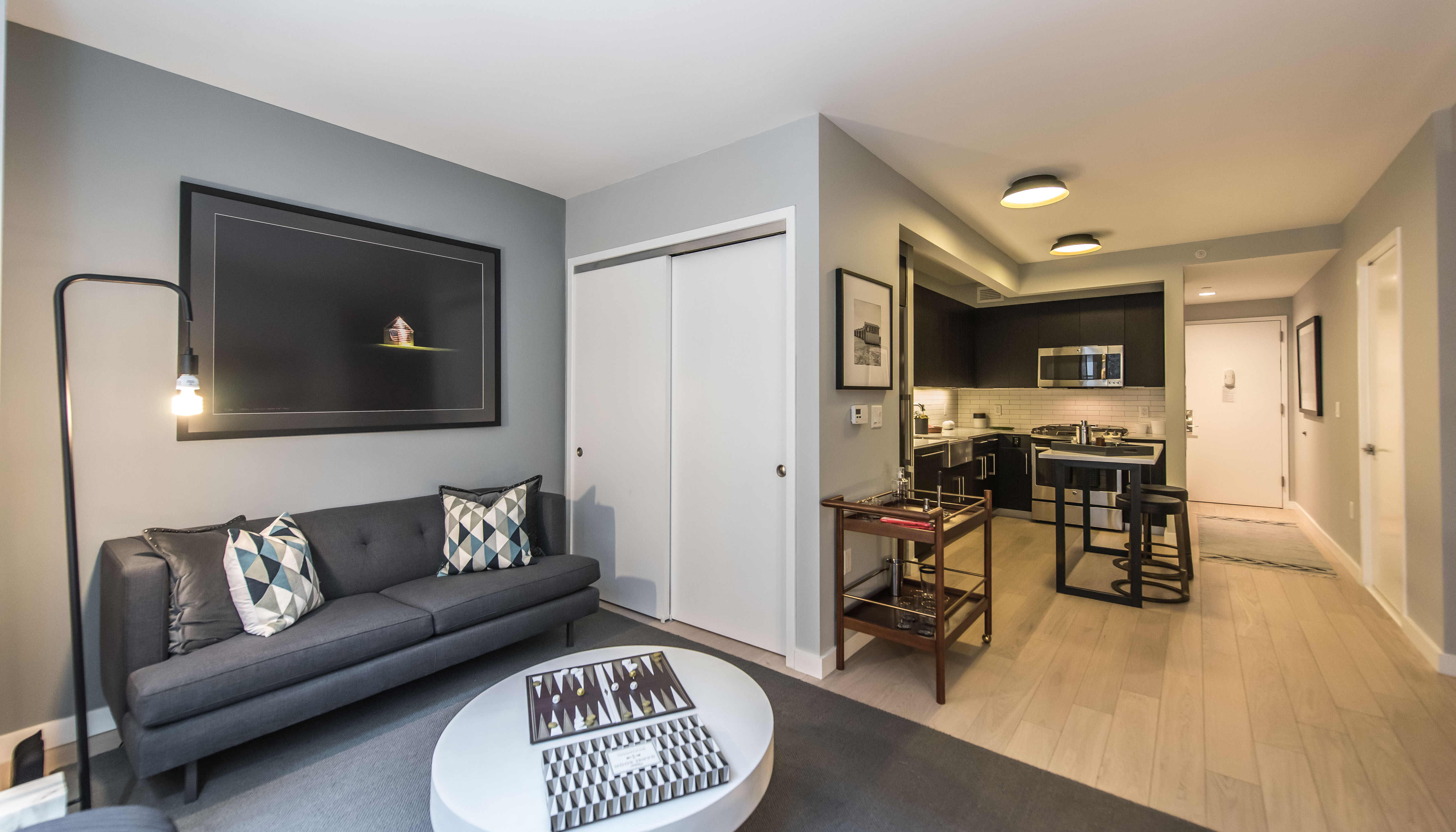 a living room with furniture and a dining table with kitchen view