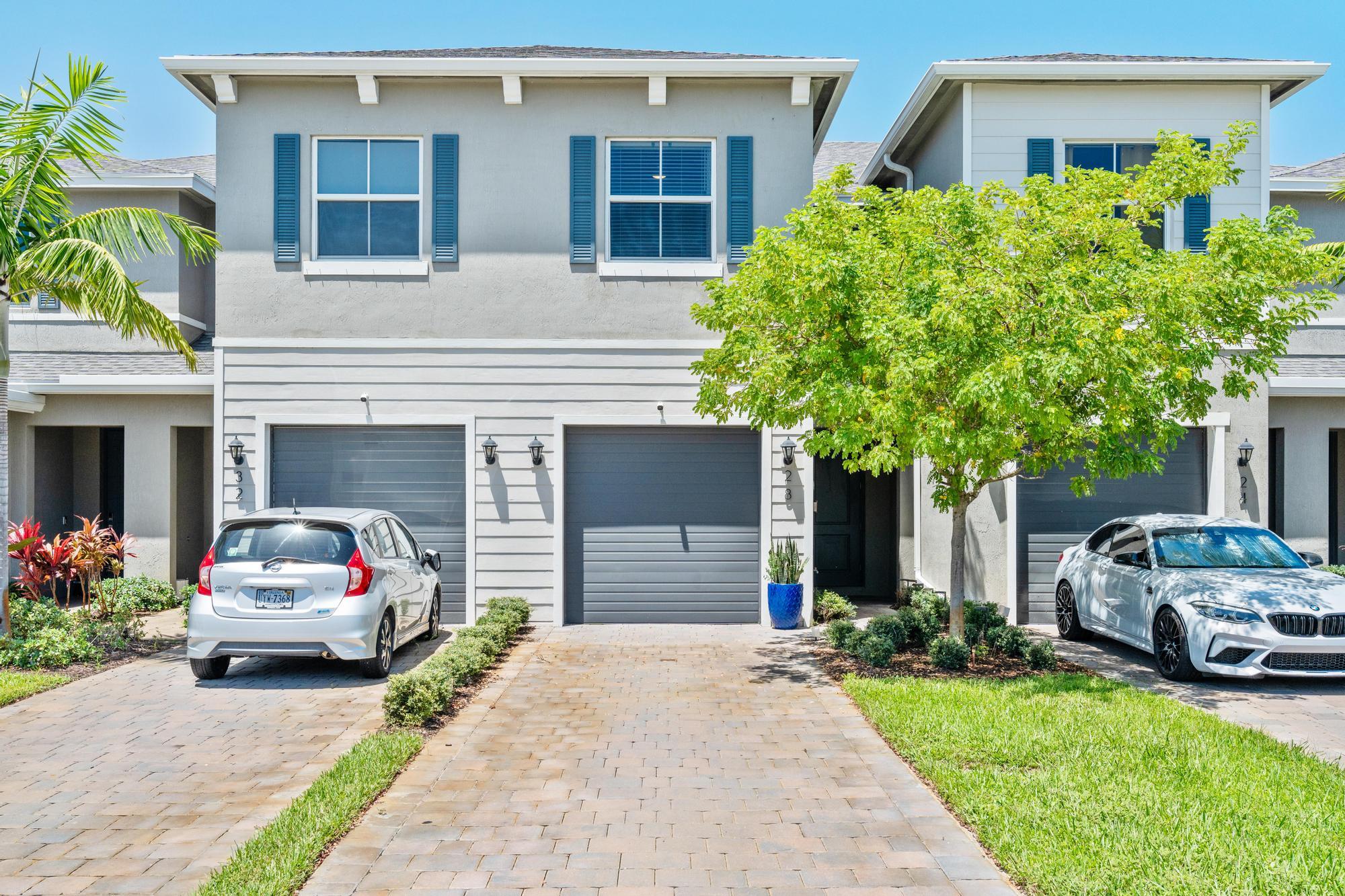 a front view of a house with a garden and garage