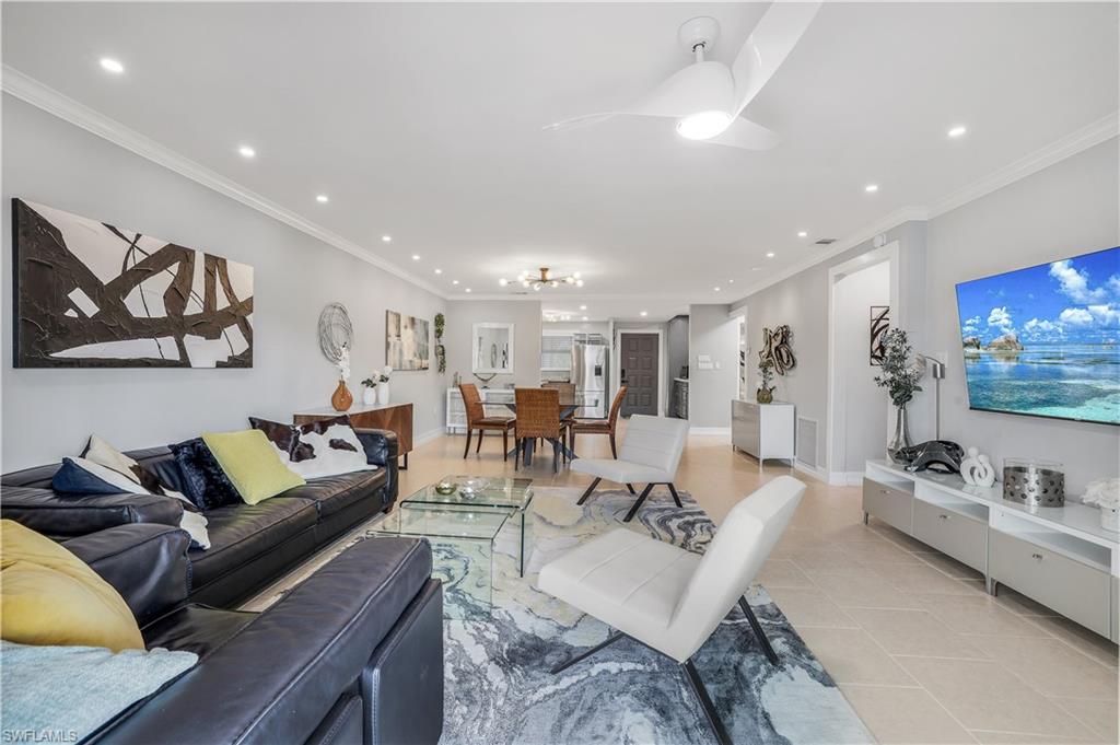 a living room with furniture kitchen view and a flat screen tv