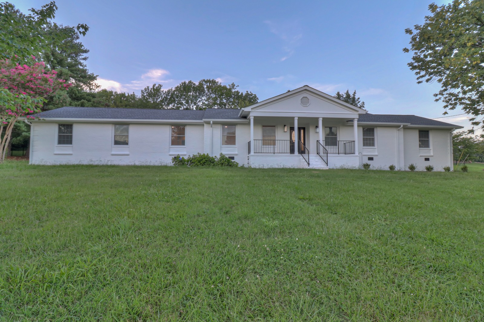 a front view of a house with a garden and yard