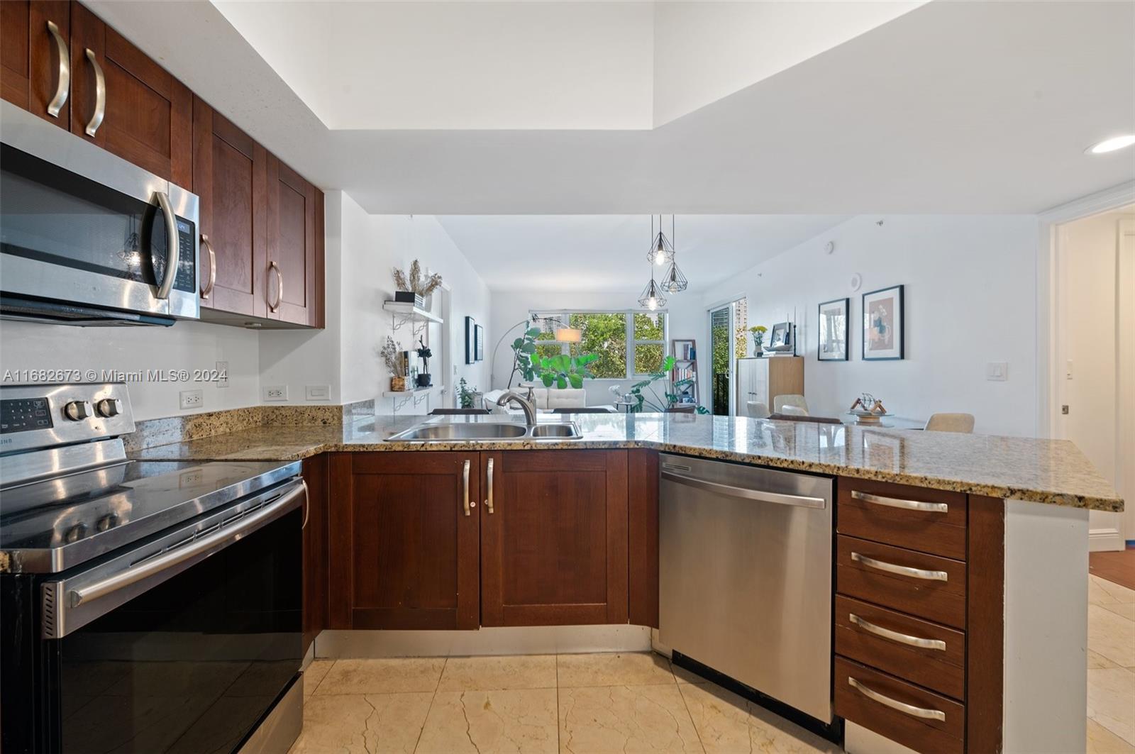 a kitchen with stainless steel appliances granite countertop a sink stove and microwave