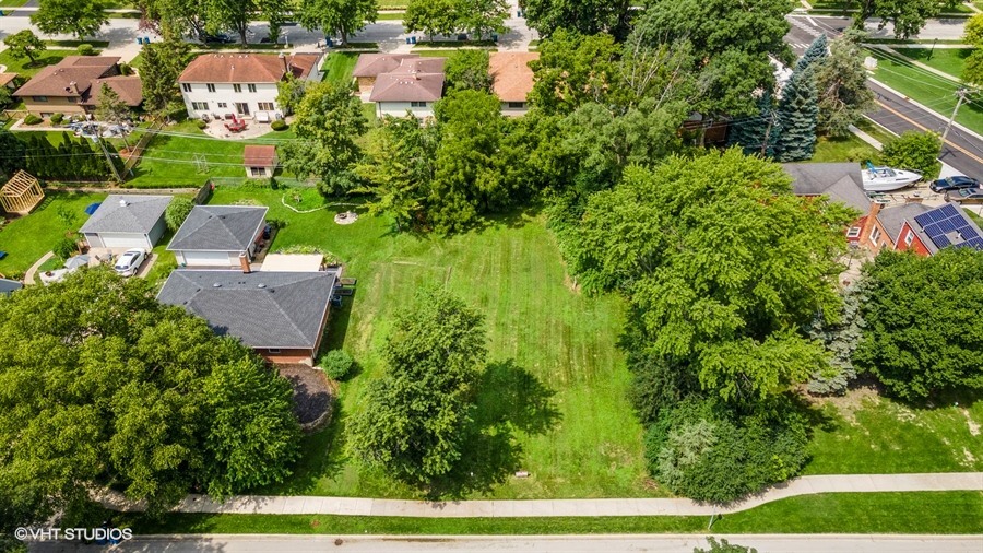 an aerial view of residential houses with outdoor space and street view