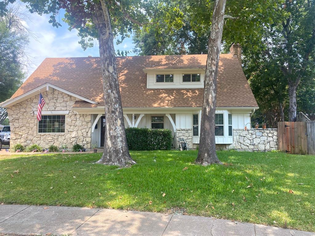 a front view of a house with a garden and trees