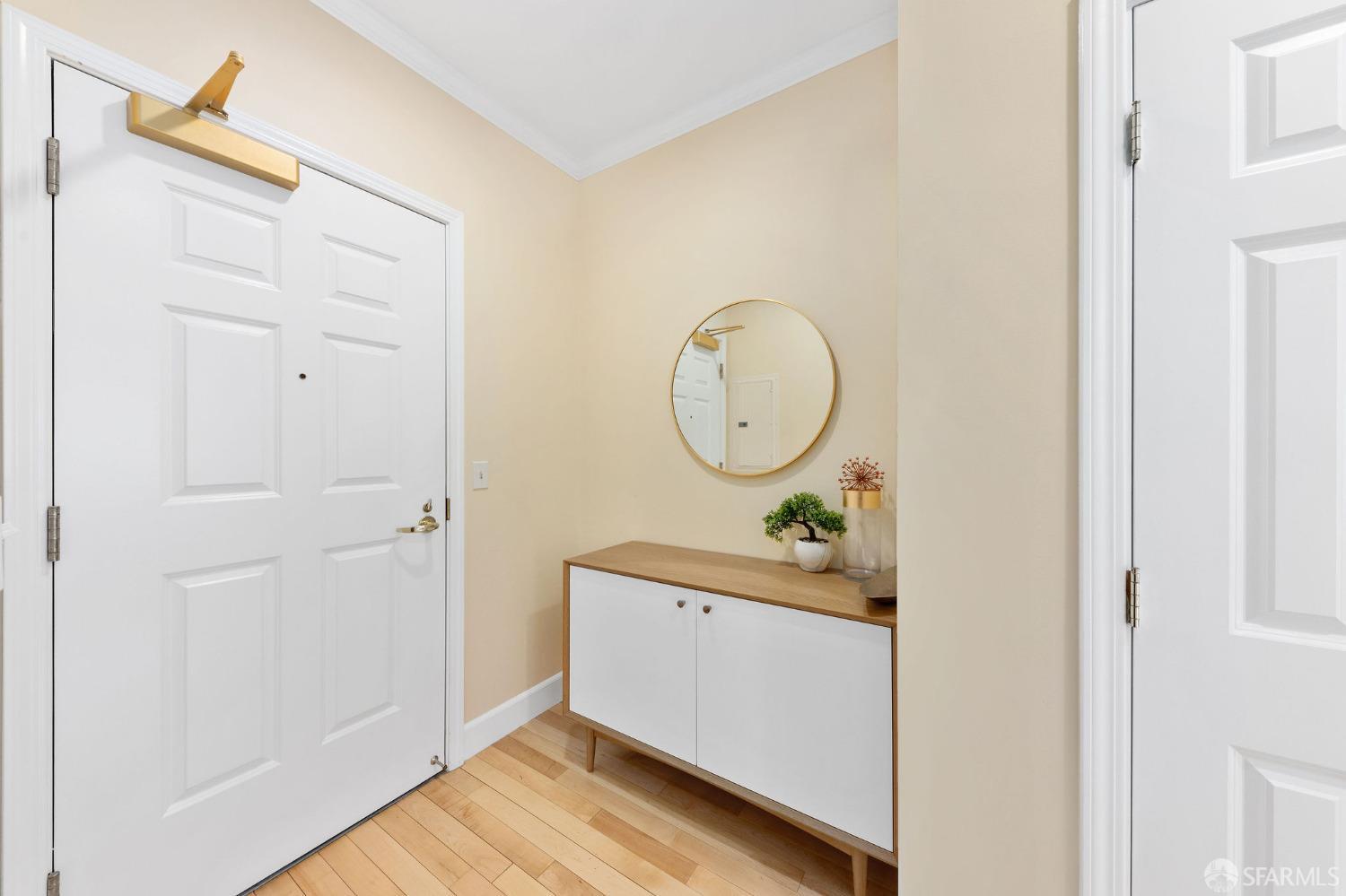 a view of a hallway with wooden floor and a mirror