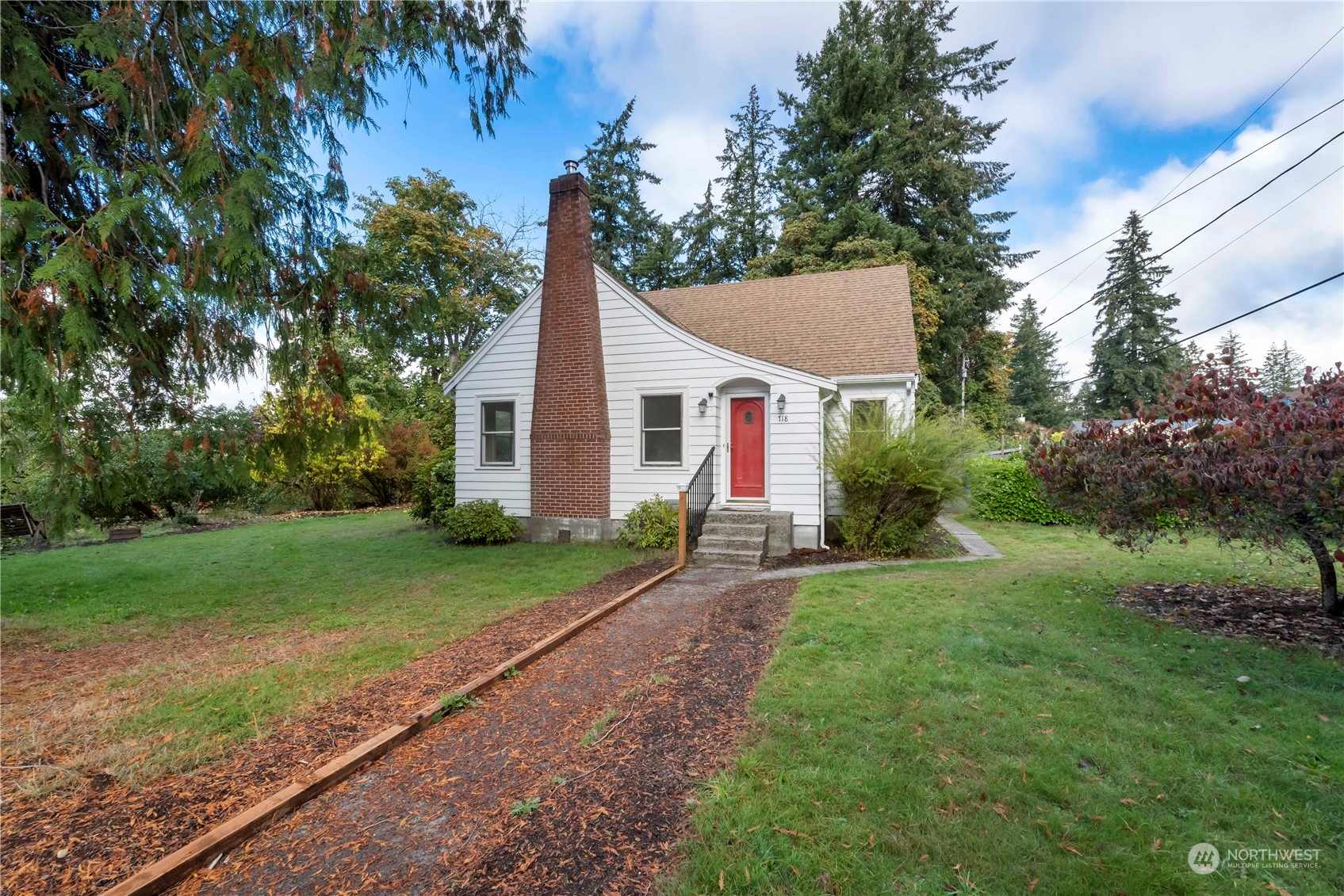 a view of a yard in front of a house with large trees