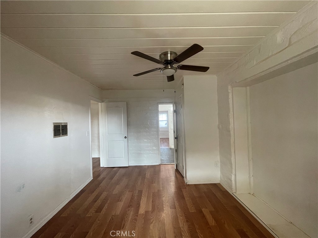 a view of a big room with wooden floor and a ceiling fan