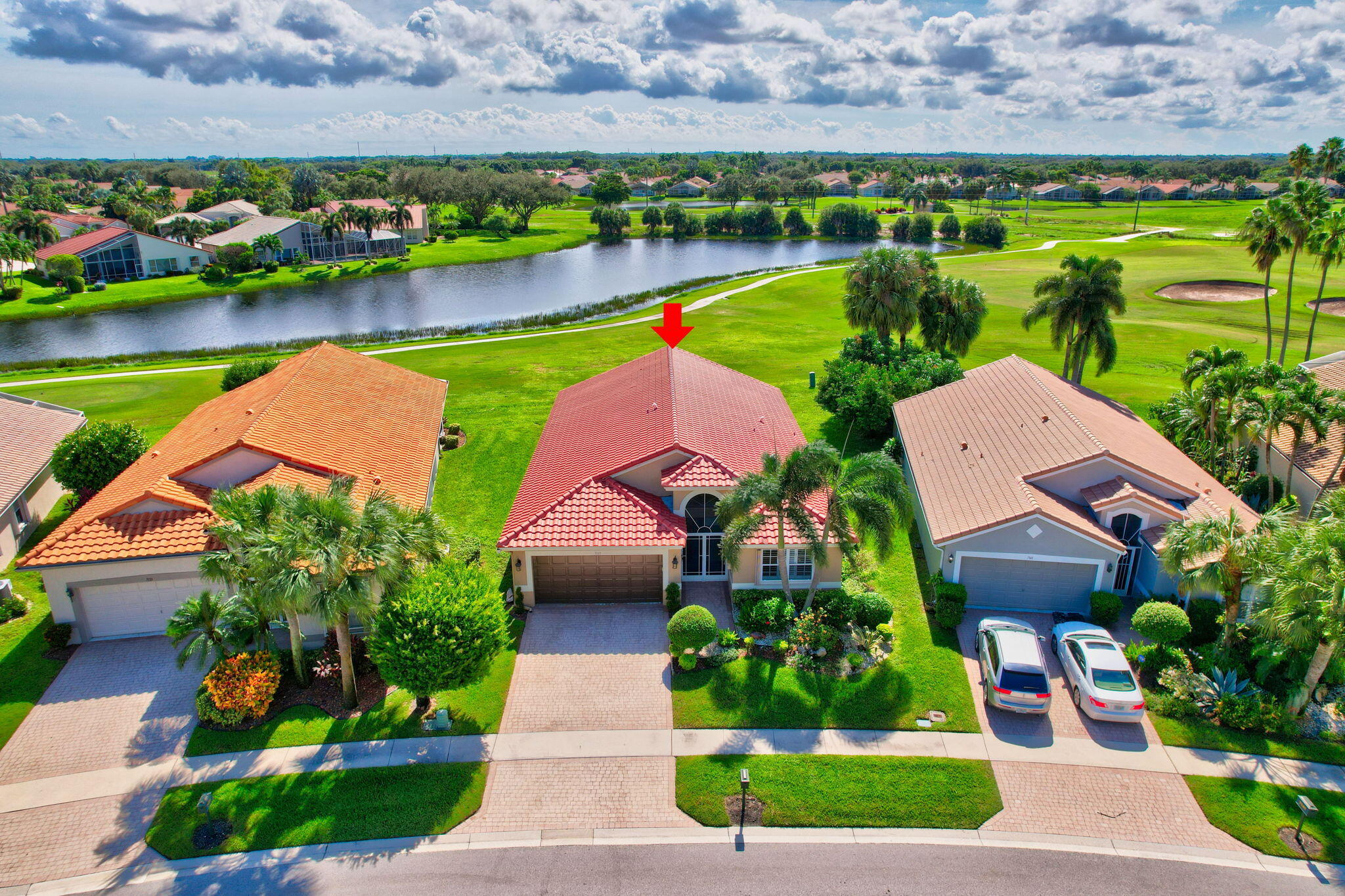 an aerial view of a house with a garden and lake view