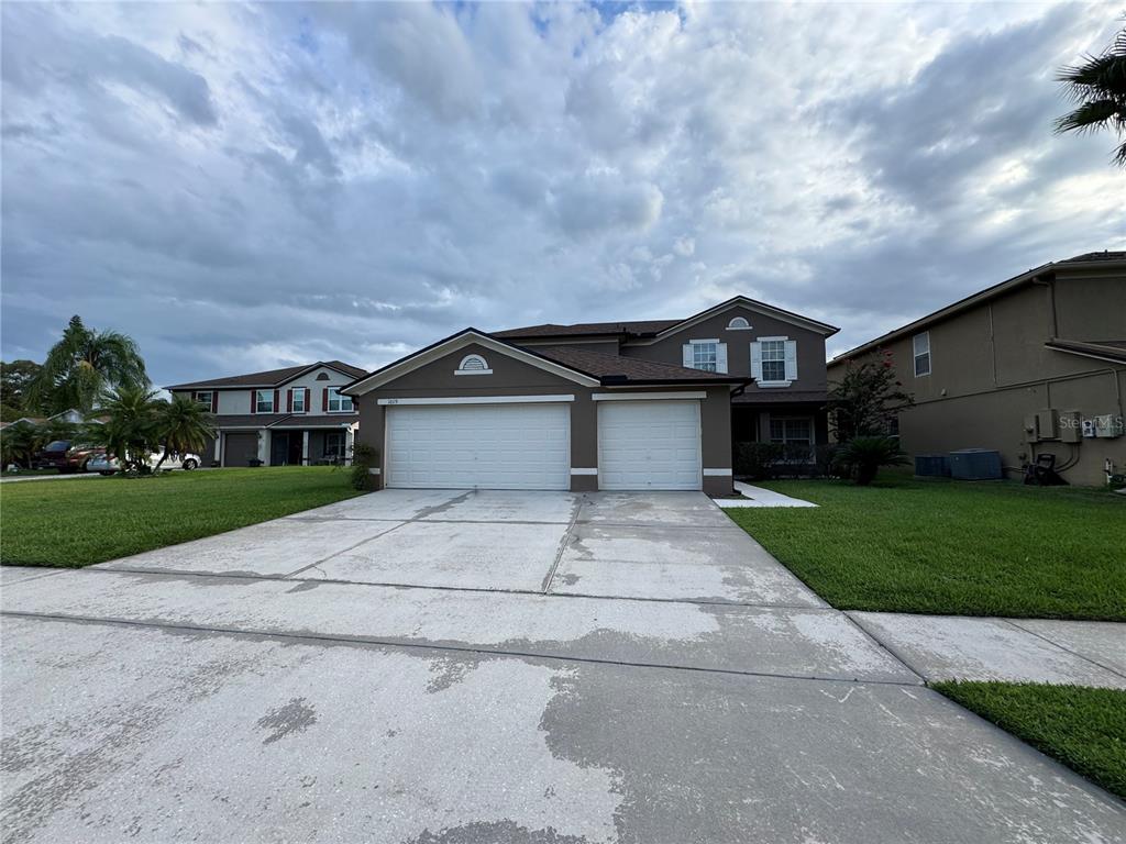 a front view of a house with a yard and garage