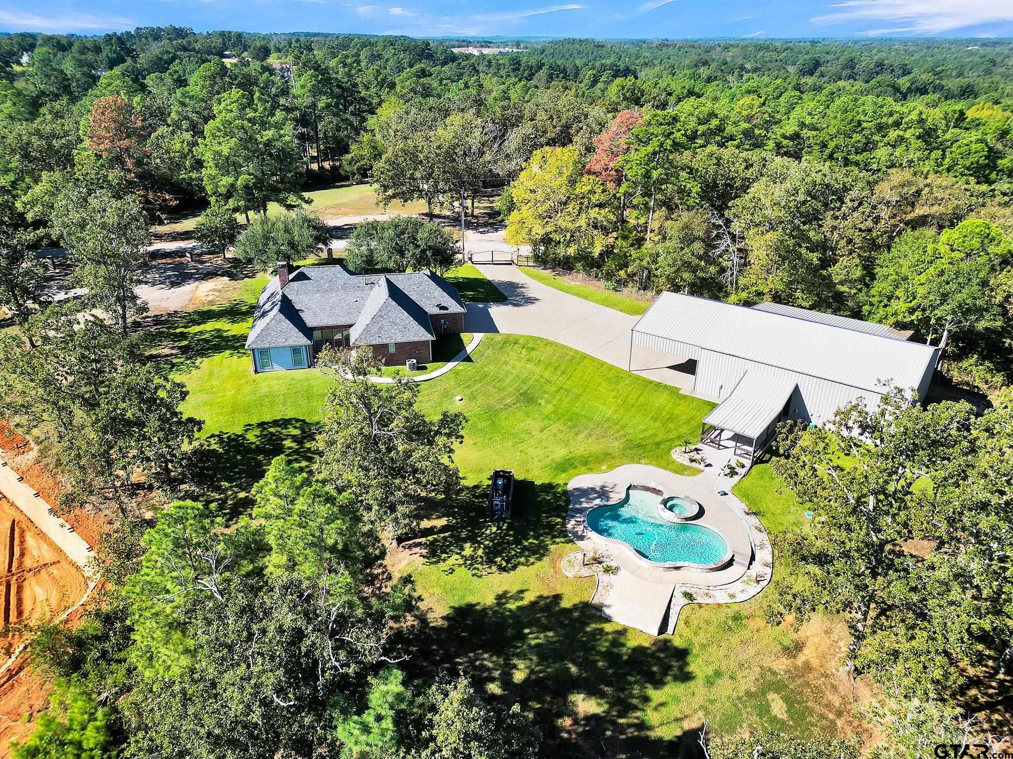 an aerial view of a house with yard swimming pool and outdoor seating