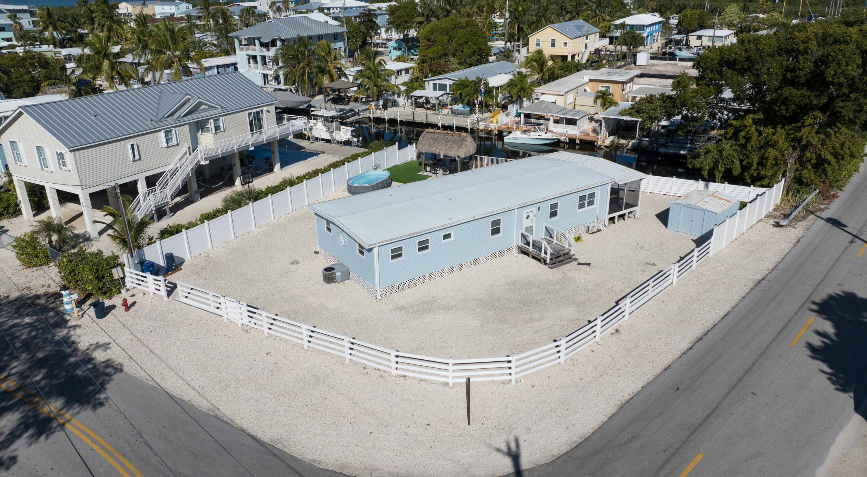 an aerial view of a house with swimming pool and large trees