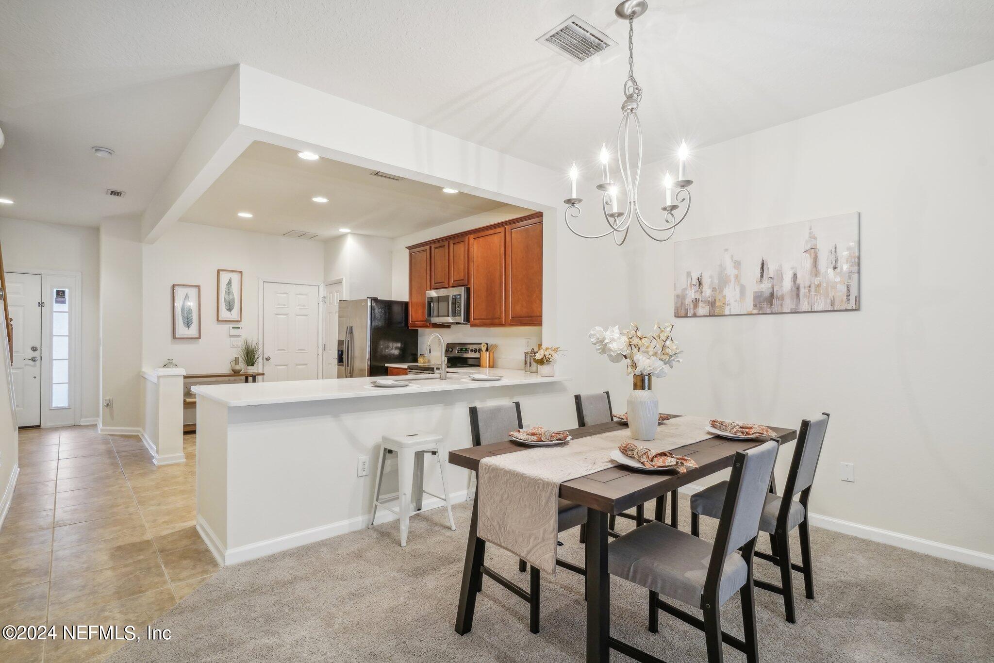 a view of a dining room with furniture a chandelier and wooden floor