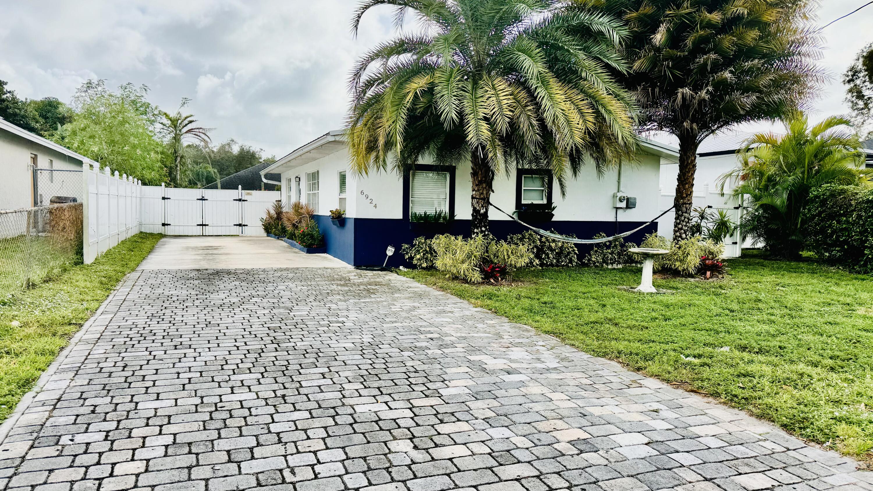 a row of palm trees in front of a house