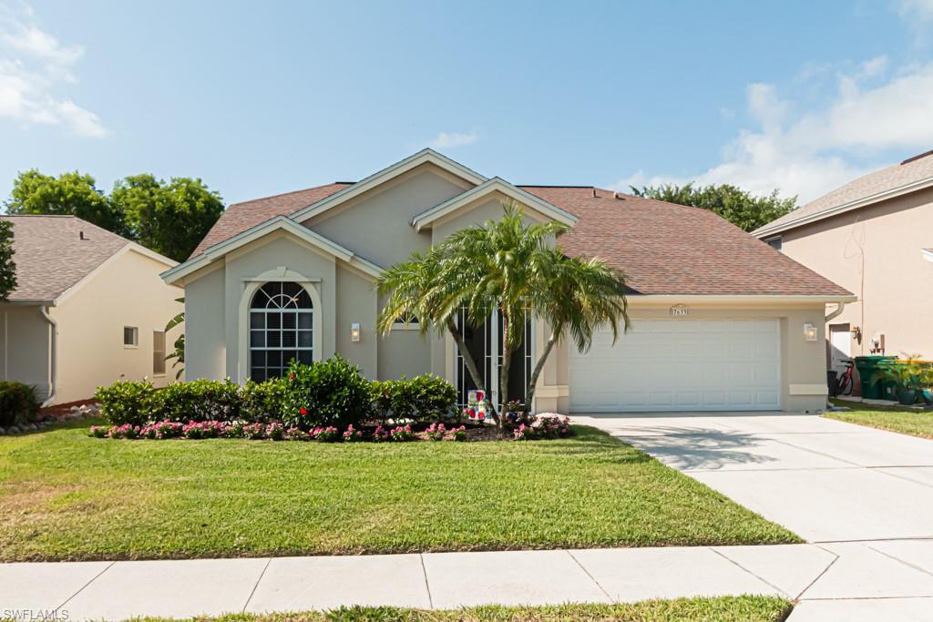 View of front facade with a garage and a front lawn