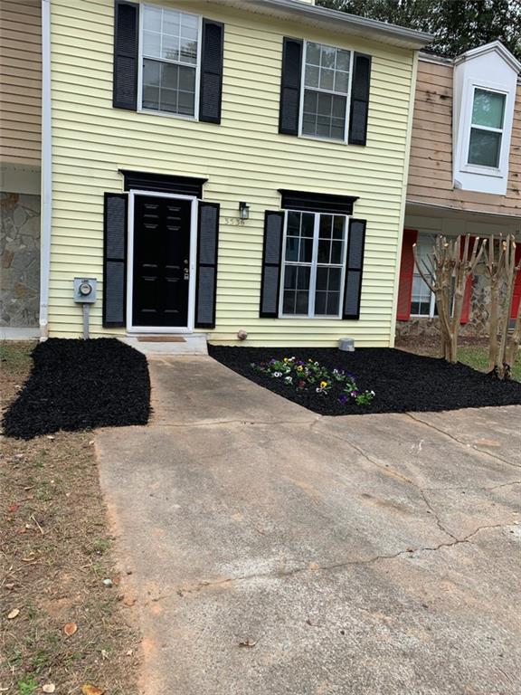 a front view of a house with a yard and parking space