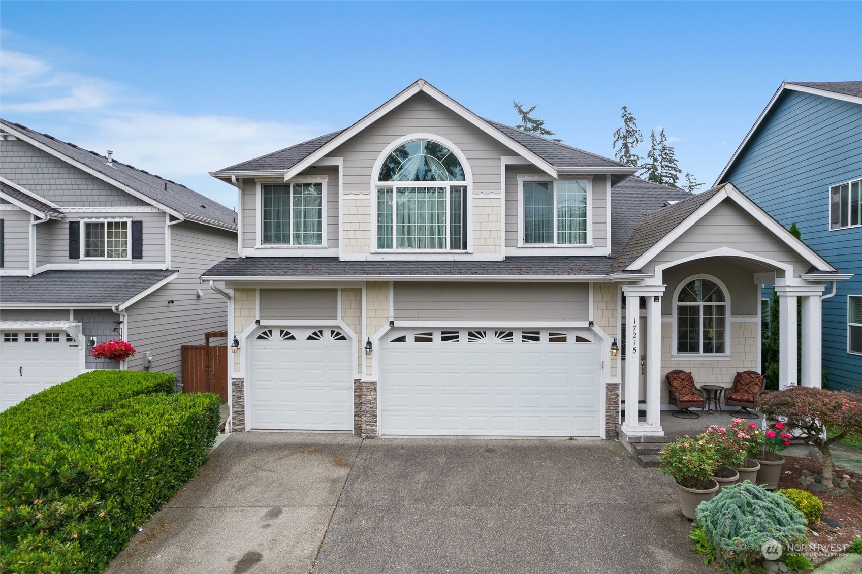 a front view of a house with a yard and trees