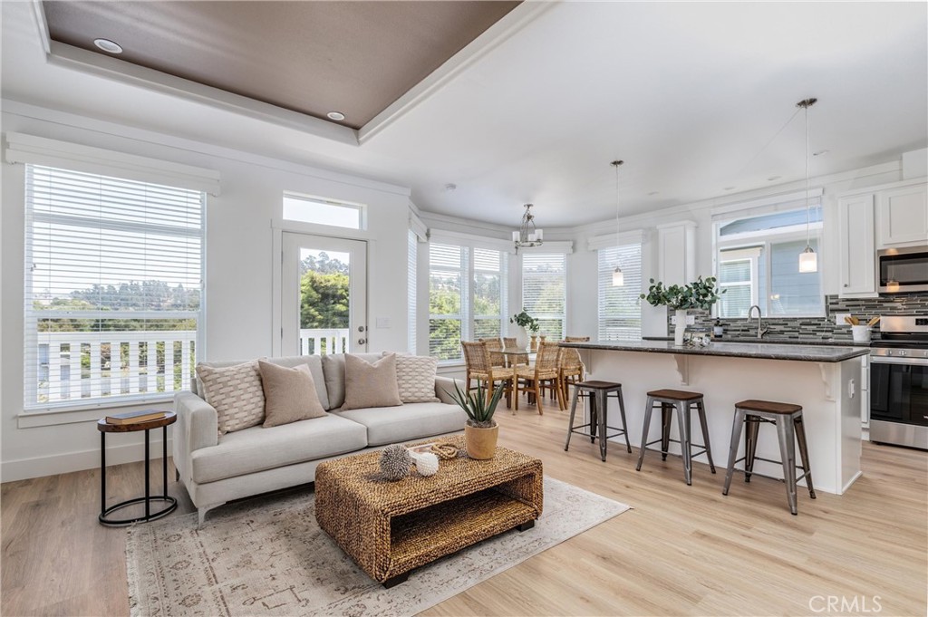 a living room with furniture a wooden floor and a large window