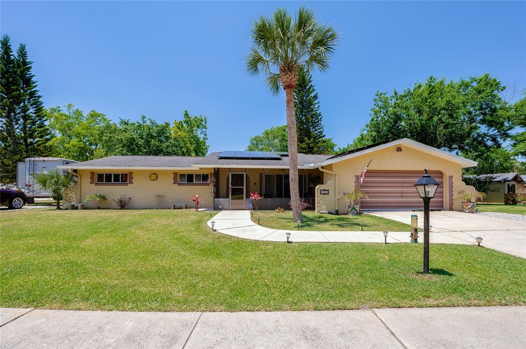 a front view of a house with a yard and trees