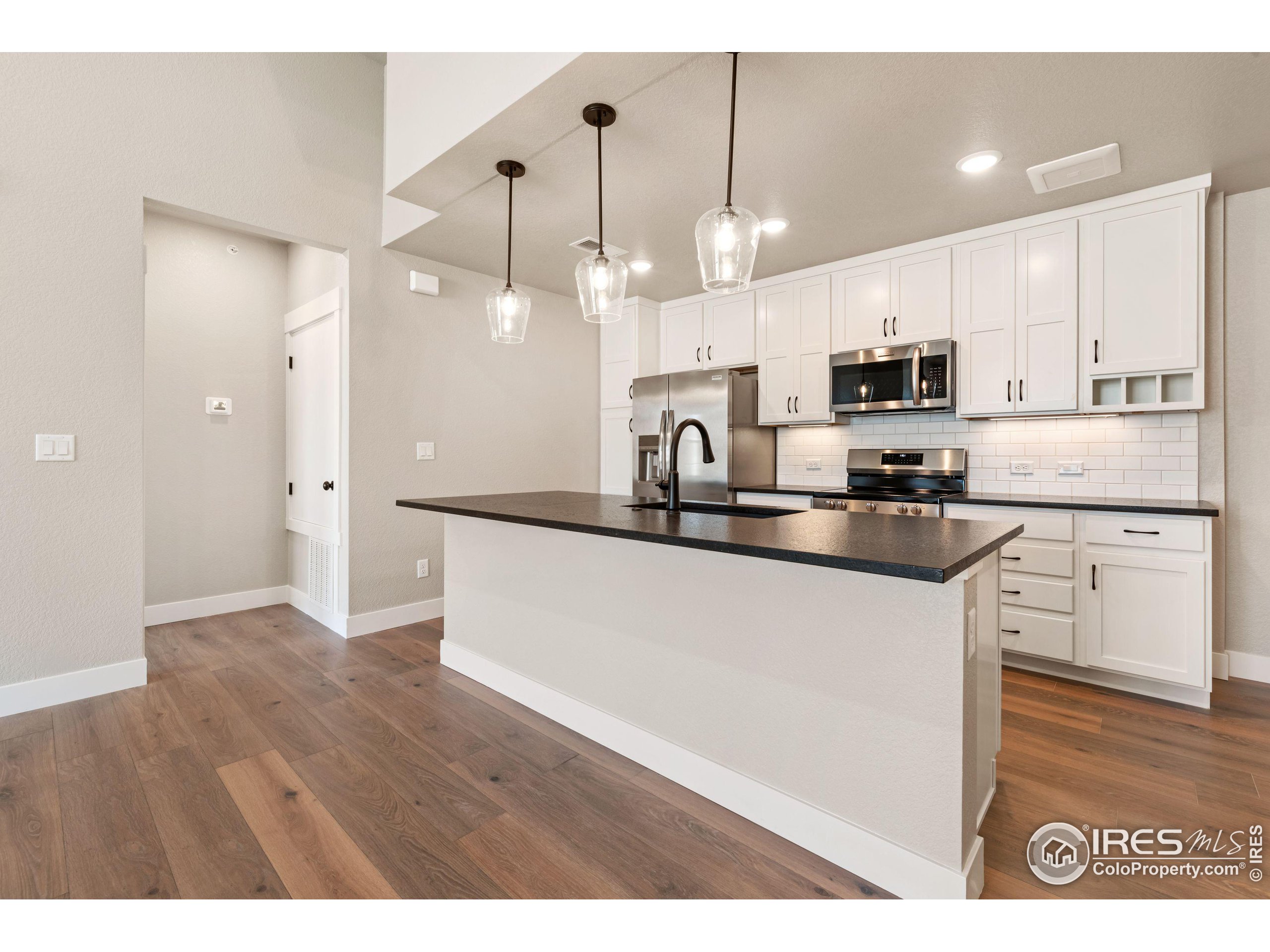 a kitchen with kitchen island white cabinets and refrigerator