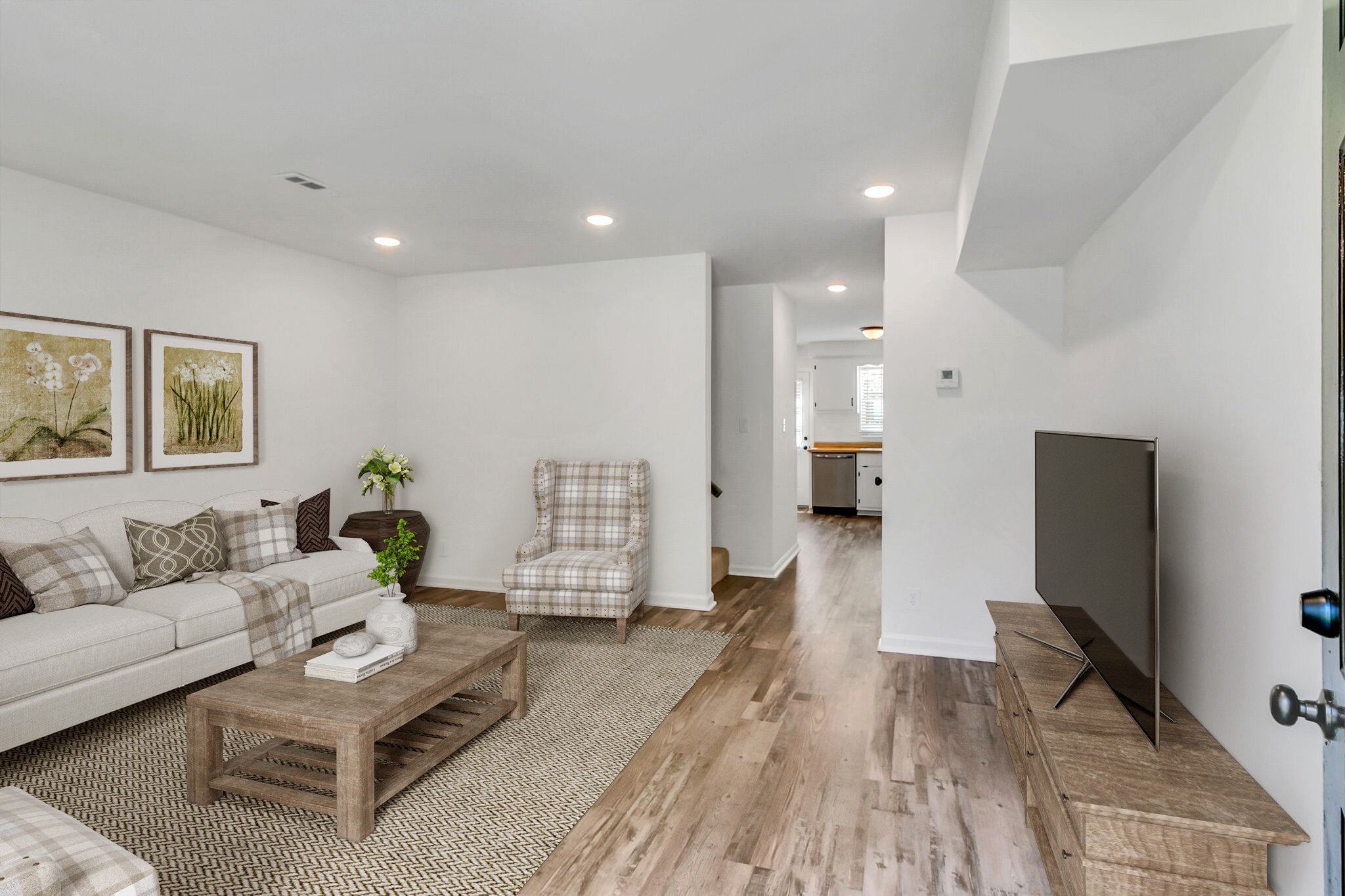 a living room with furniture and a wooden floor