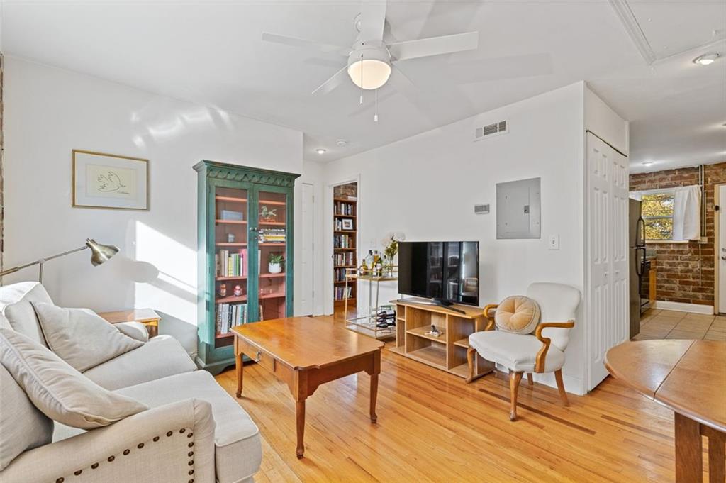 a living room with furniture a flat screen tv and kitchen view