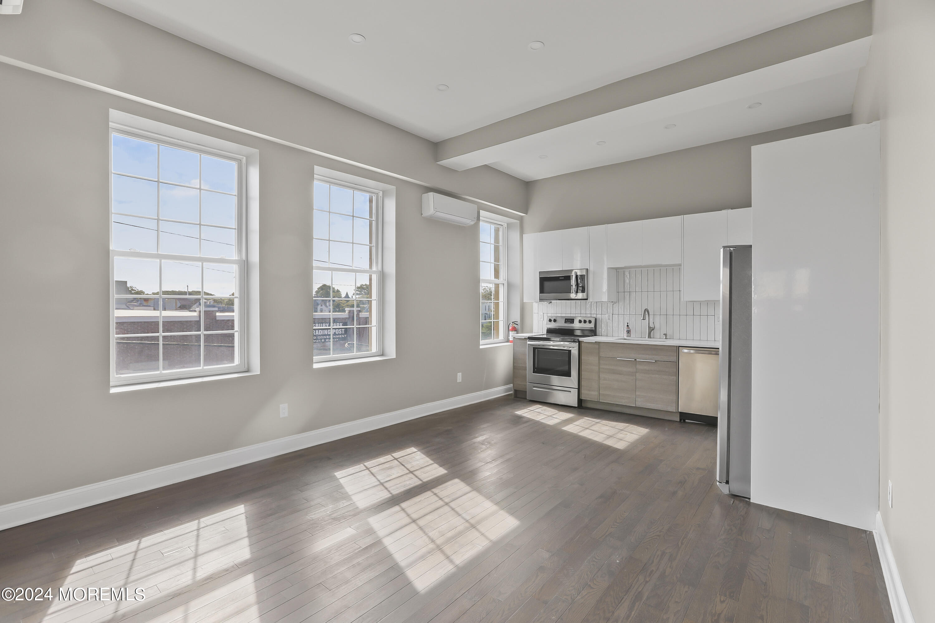 a kitchen with a white cabinets and wooden floor