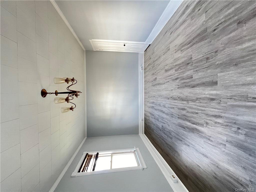 Spare room featuring hardwood / wood-style flooring and crown molding