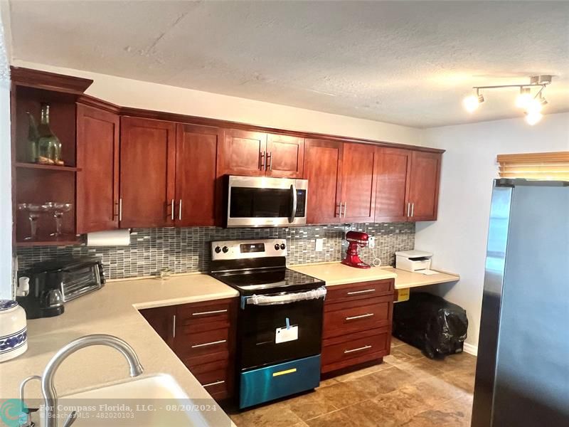 a kitchen with a sink stove top oven and microwave