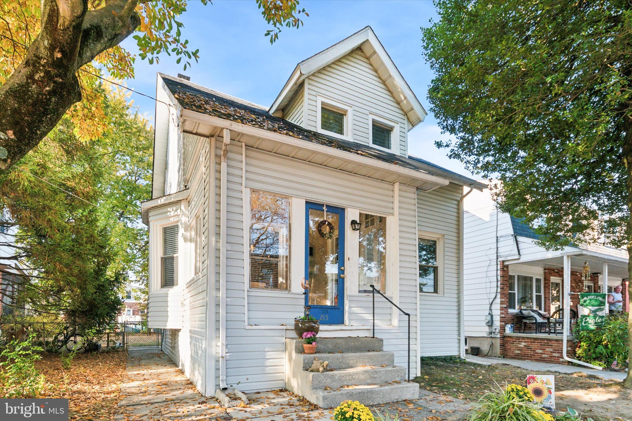 a front view of a house with a tree