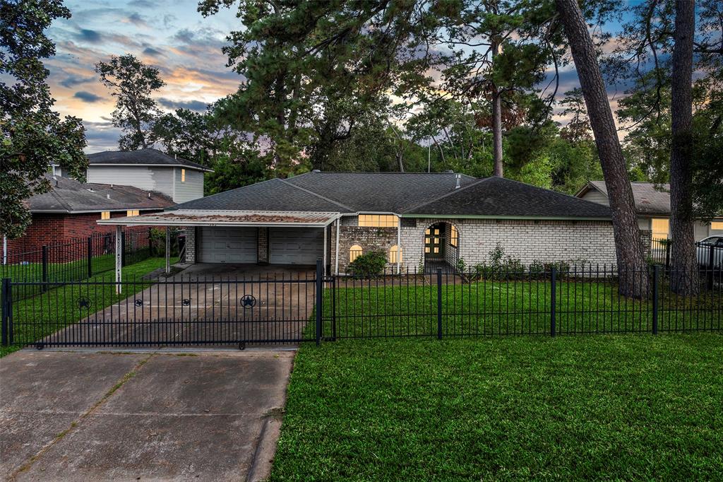 a view of a house with a small yard and a large tree