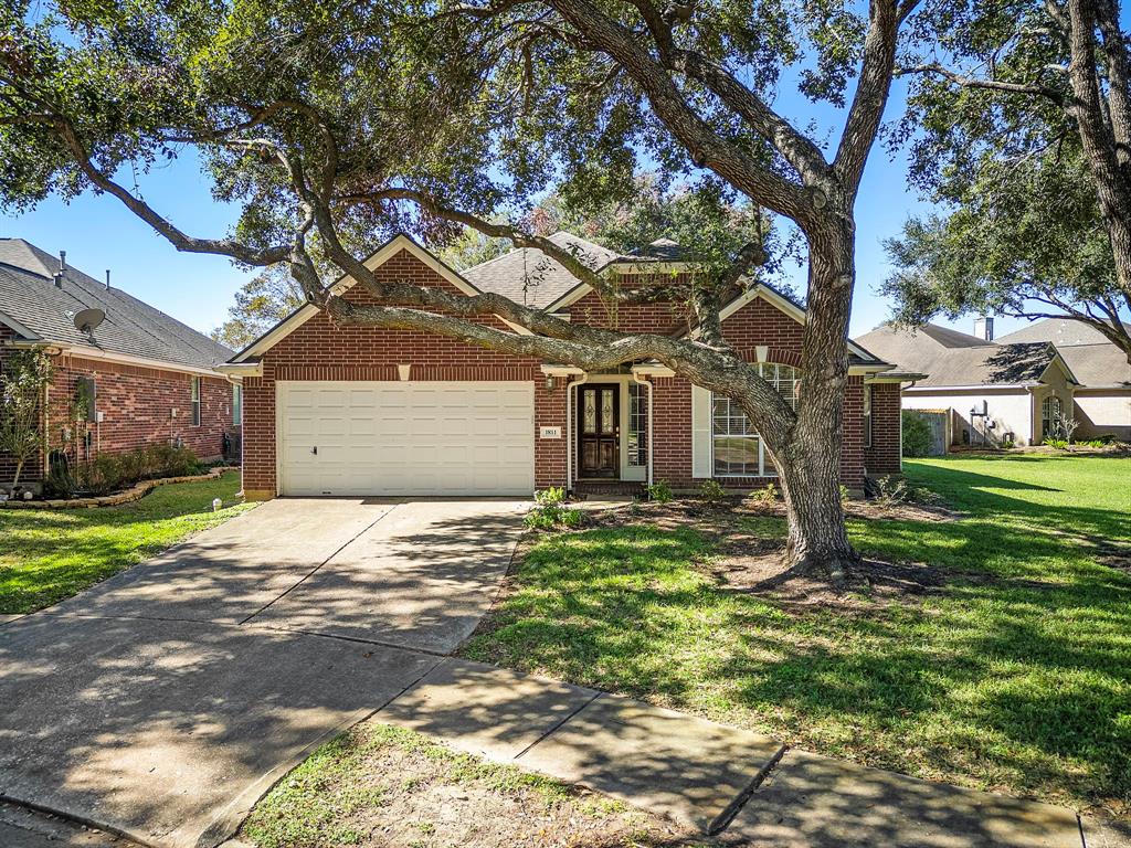 Charming single-story brick home featuring a two-car garage, nestled under mature oak trees in a well-kept neighborhood