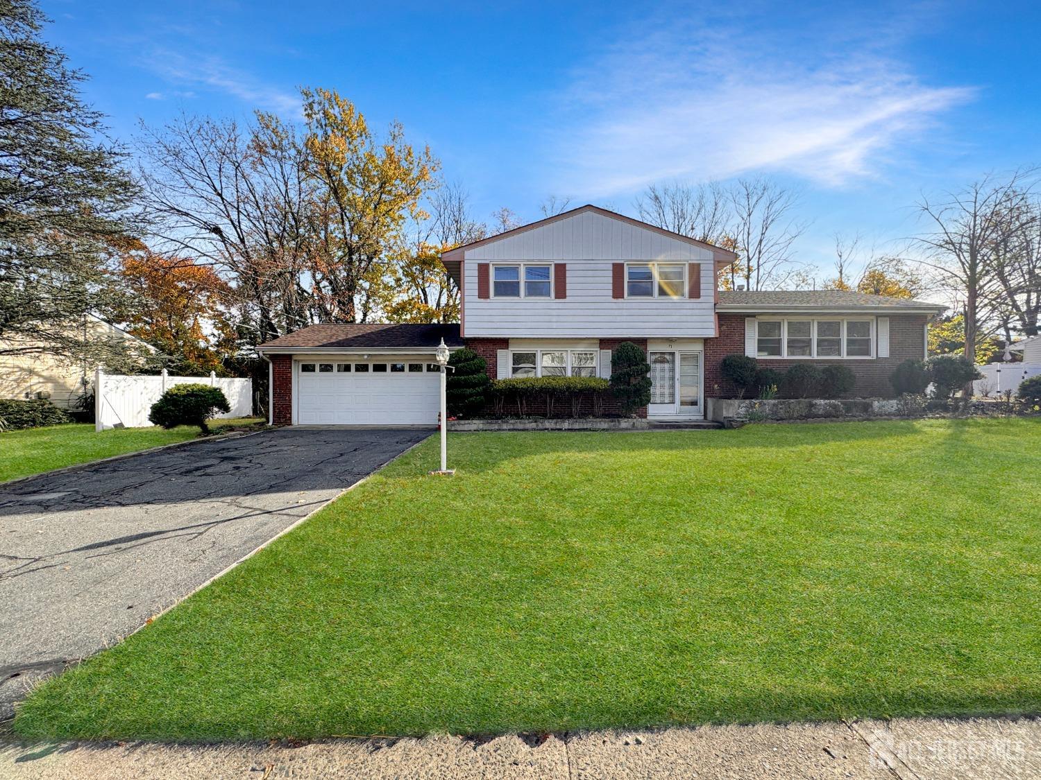 a front view of a house with a yard and trees