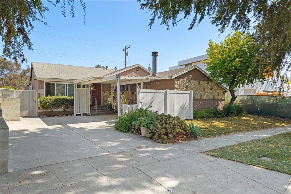 a front view of a house with a yard and potted plants