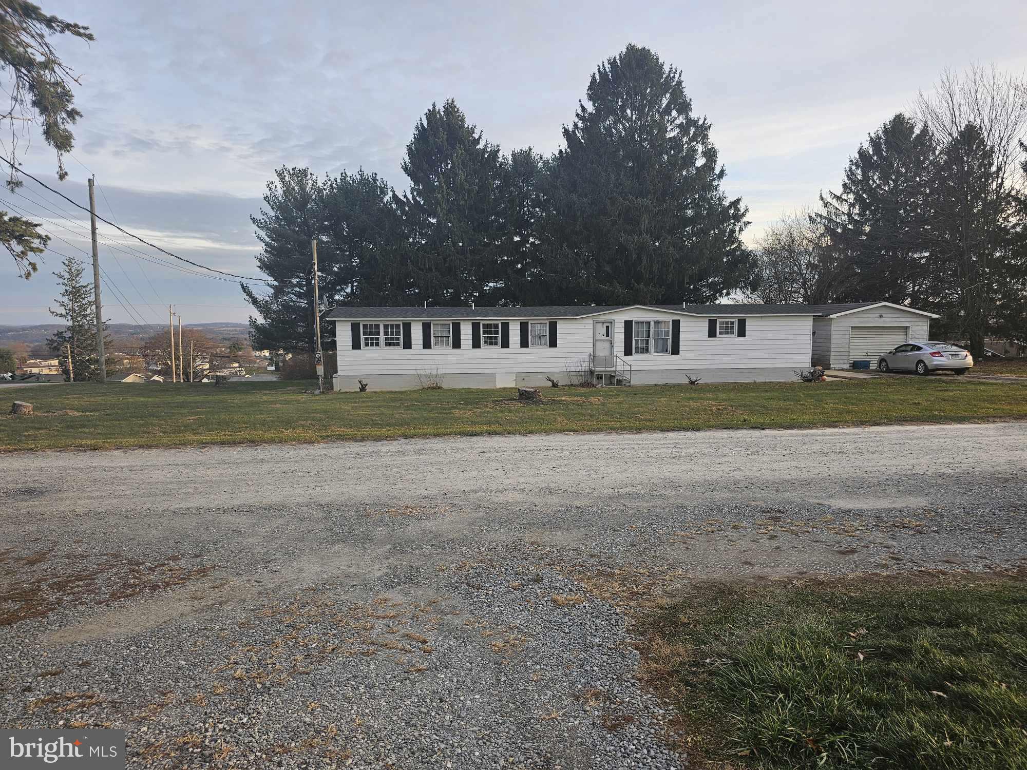 a front view of a house with a yard and trees