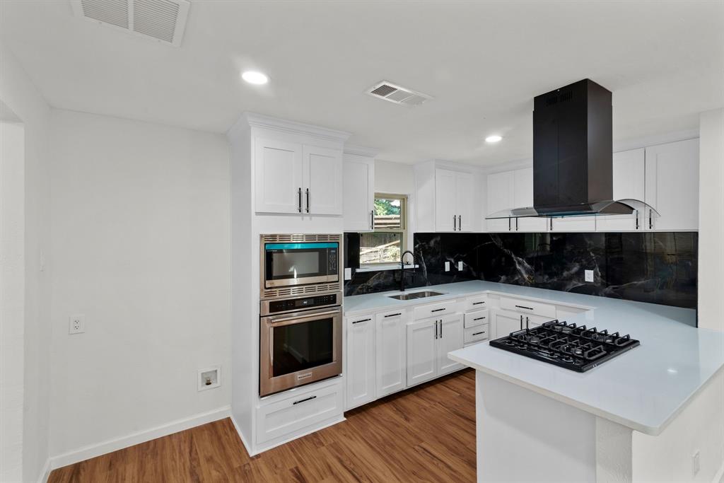 a kitchen with a stove and white cabinets