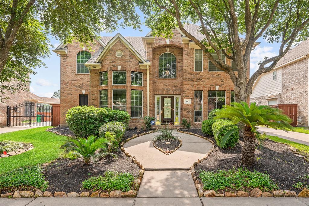 Welcome Home! A brick elevation is surrounded by lush landscape and mature trees offering great curb appeal.
