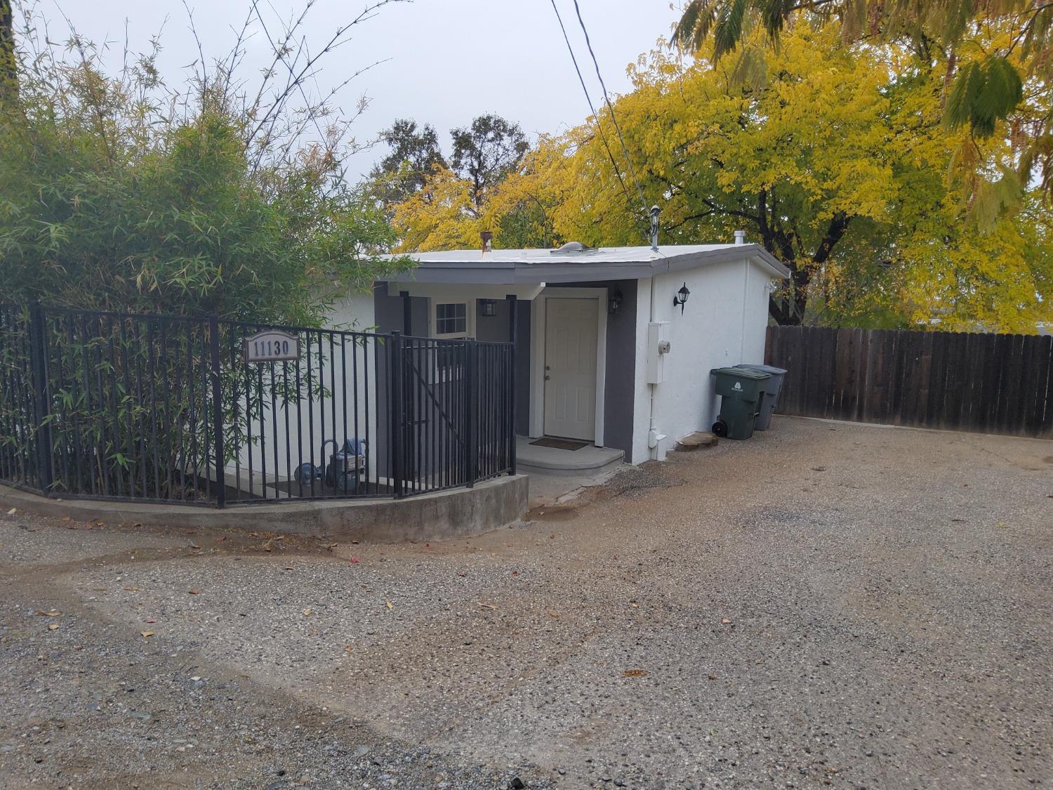 a view of a house with a yard and large tree