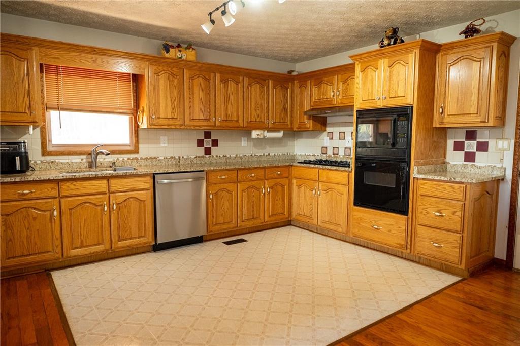 a kitchen with stainless steel appliances granite countertop a stove sink and cabinets