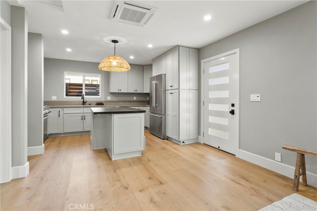 a kitchen with kitchen island a sink stainless steel appliances and cabinets