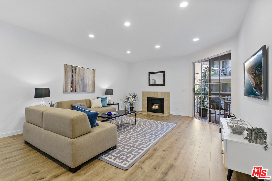 a living room with furniture a flat screen tv and a fireplace