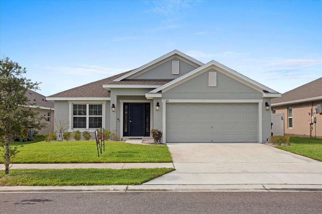 a front view of a house with a yard and garage