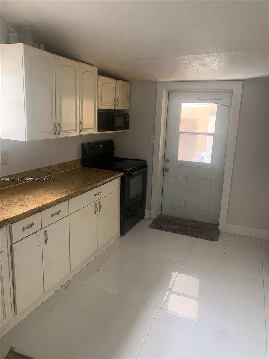 a kitchen with granite countertop white cabinets and stainless steel appliances