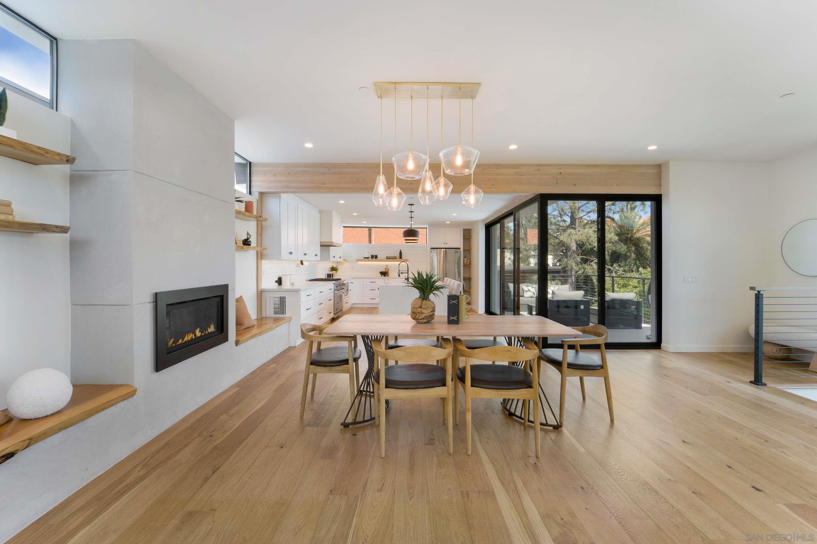 a dining room with furniture a fireplace and wooden floor