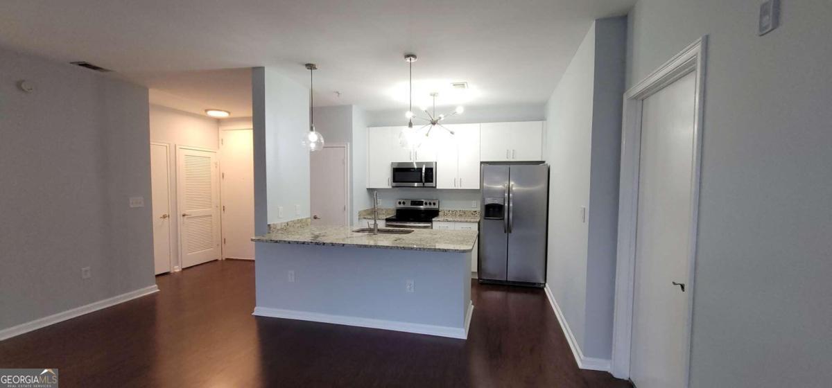 a kitchen with kitchen island white cabinets and stainless steel appliances